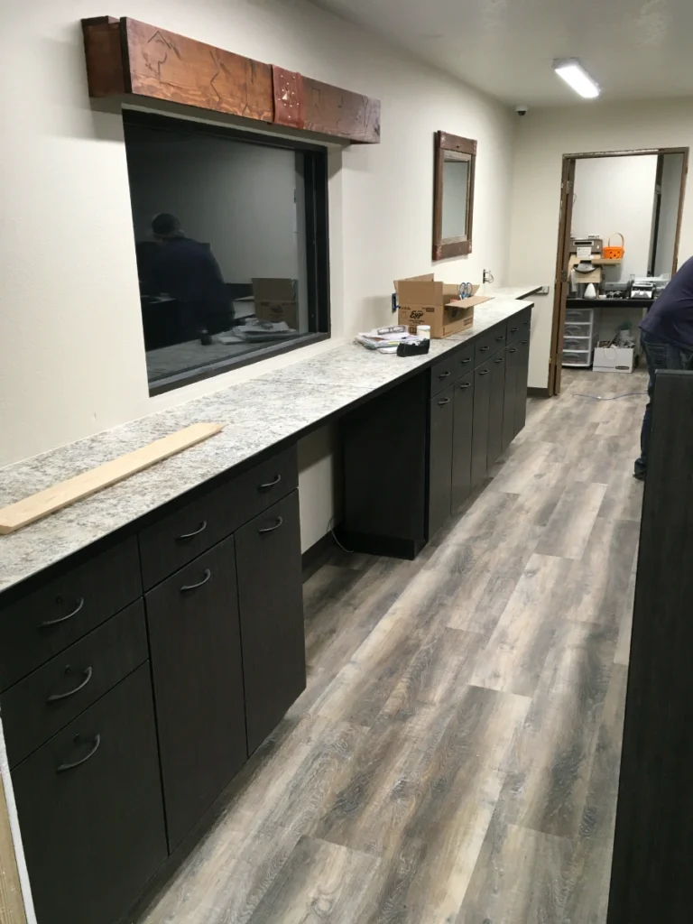 Bank teller counter with solid surface top and modular cabinetry being installed over a weekend