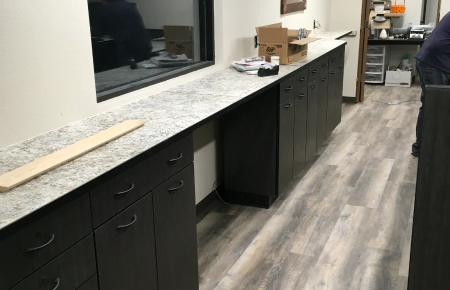Bank teller counter with solid surface top and modular cabinetry being installed over a weekend