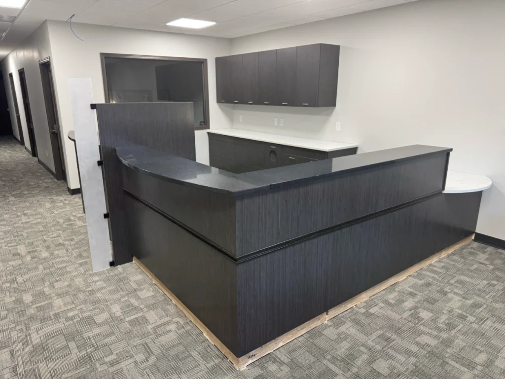 L-shaped modular customer service counter with granite transaction top and wall-hung cabinets